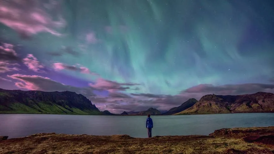 An awe-inspiring landscape photograph of mountains under a starry sky.