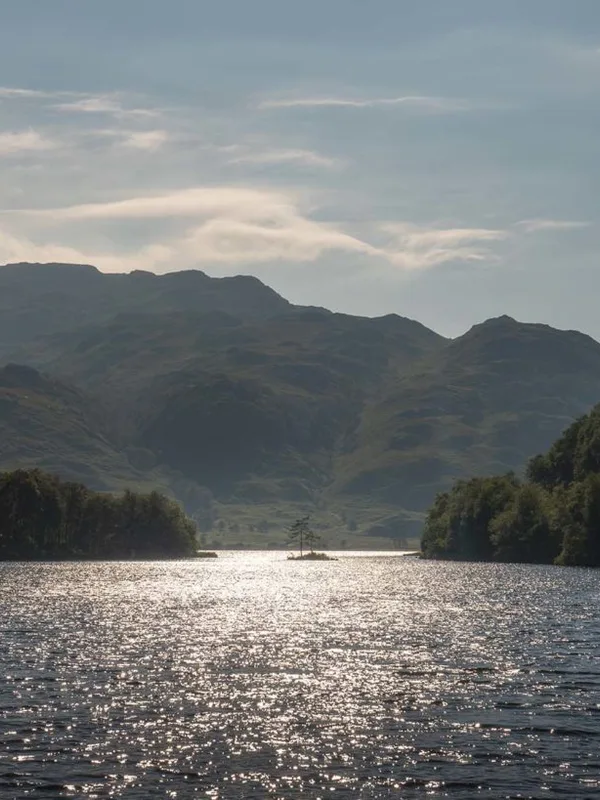 Misty mountains of the Scottish highlands at dawn, titled Highland Whispers.