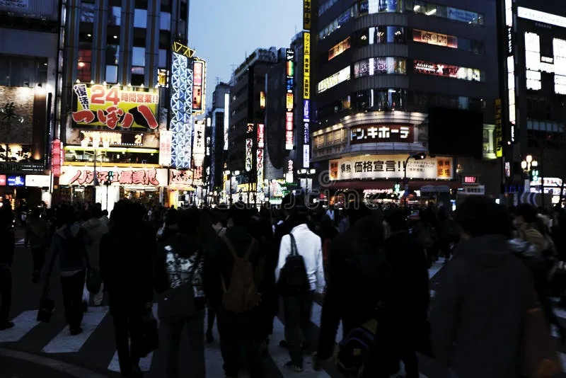 A dynamic photo of a busy Tokyo street at night, filled with neon signs and motion blur.